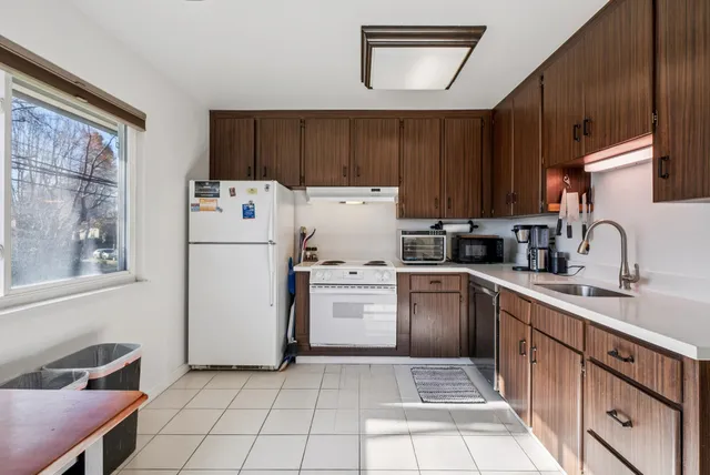a kitchen with a refrigerator sink and cabinets