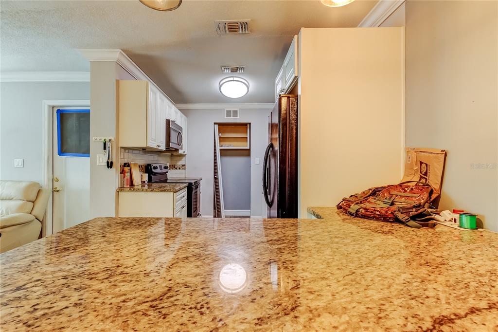 4532 Devonshire Road Tampa, FL 33634 - Photo 9 of 37 a kitchen with stainless steel appliances kitchen island granite countertop a refrigerator and a stove top oven