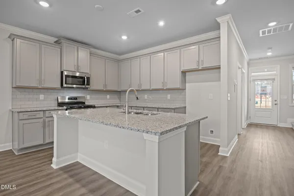 a kitchen with stainless steel appliances granite countertop a stove a sink and a refrigerator