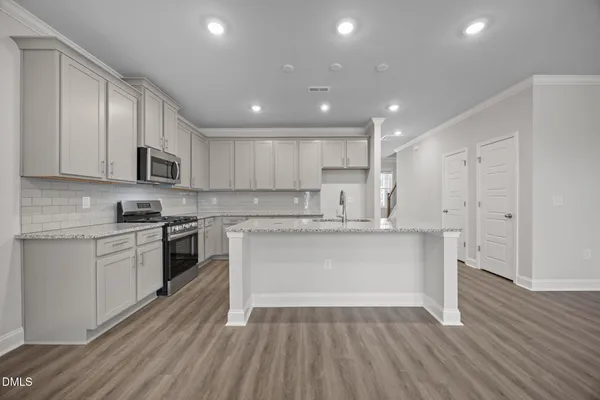 a kitchen with kitchen island granite countertop a sink and white appliances