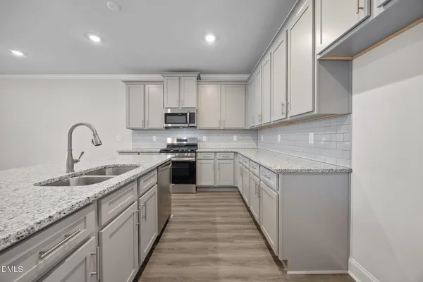 a kitchen with granite countertop a sink and wooden floor