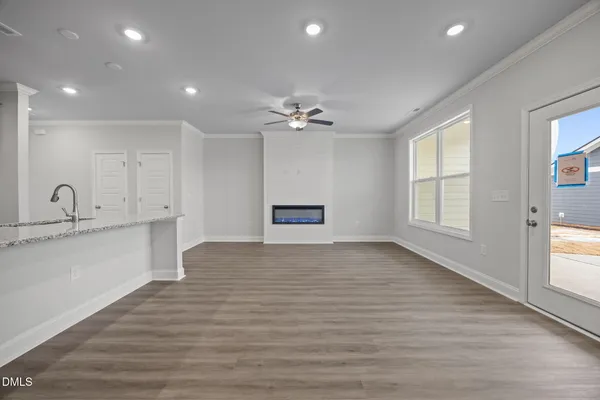 a view of a kitchen with a sink and dishwasher a refrigerator with wooden floor