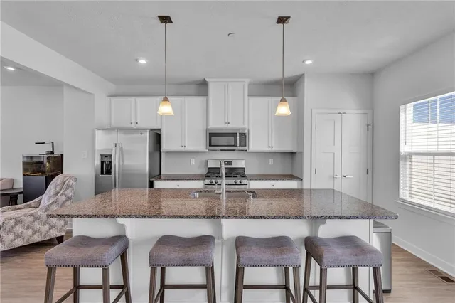a kitchen with granite countertop kitchen island cabinets and stainless steel appliances