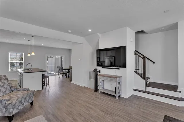 a living room with furniture a flat screen tv and kitchen view