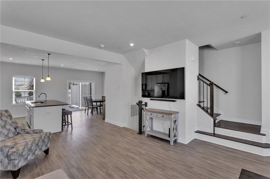 7406 Chestnut Way Gibsonia, PA 15044 - Photo 7 of 42 a living room with furniture a flat screen tv and kitchen view