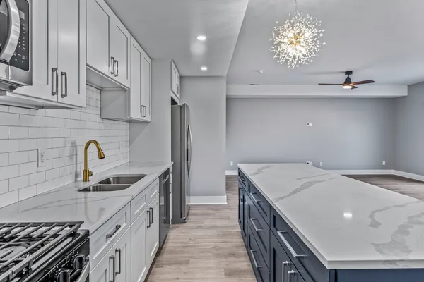 a kitchen that has a sink a stove and a oven
