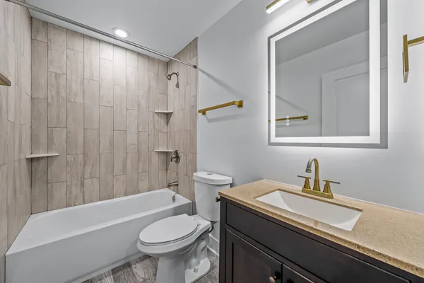 a bathroom with a sink a toilet and shower