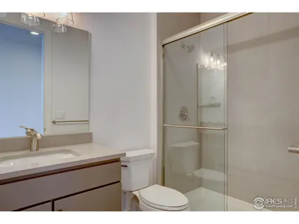 a bathroom with a sink toilet a mirror and shower