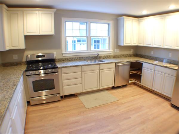 33 Tanglewood Road, Unit 1 Newton, MA 02459 - Photo 3 of 29 a kitchen with granite countertop a stove a sink and a window