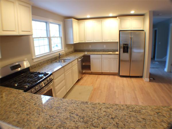 33 Tanglewood Road, Unit 1 Newton, MA 02459 - Photo 4 of 29 a kitchen with granite countertop a stove a refrigerator and a sink