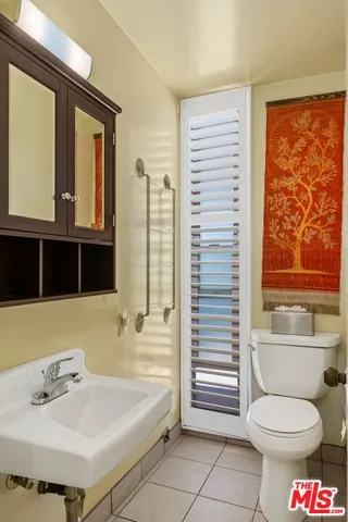 a bathroom with a granite countertop sink and a toilet