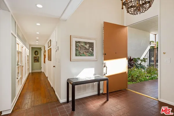 a hallway with furniture and a potted plant