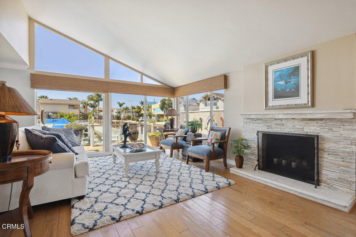 2231 Peninsula Road Oxnard, CA 93035 - Photo 5 of 40 a living room with furniture large window and a fireplace