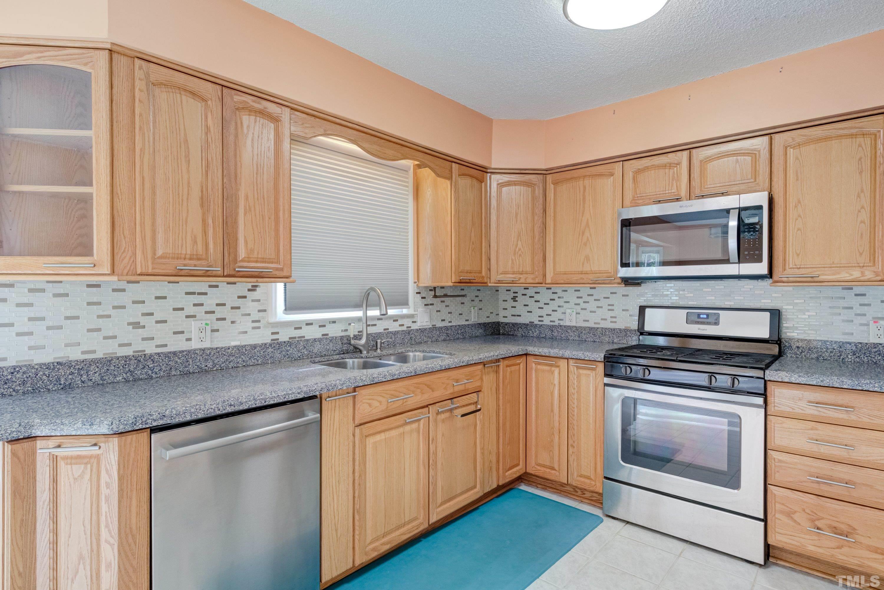 7008 Ray Road Raleigh, NC 27613 - Photo 2 of 36 a kitchen with granite countertop a sink stainless steel appliances and cabinets