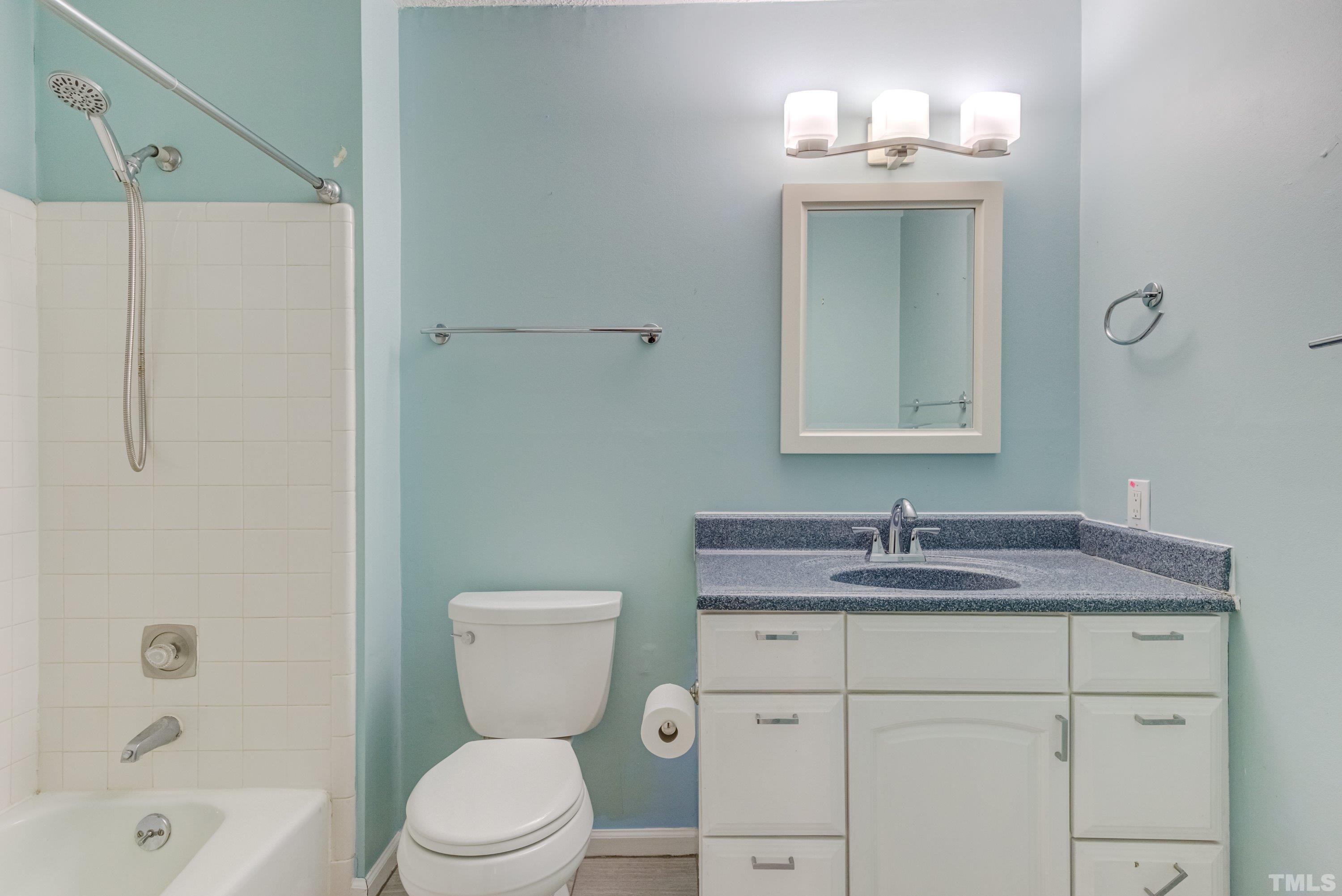 7008 Ray Road Raleigh, NC 27613 - Photo 26 of 36 a bathroom with a toilet sink vanity and mirror