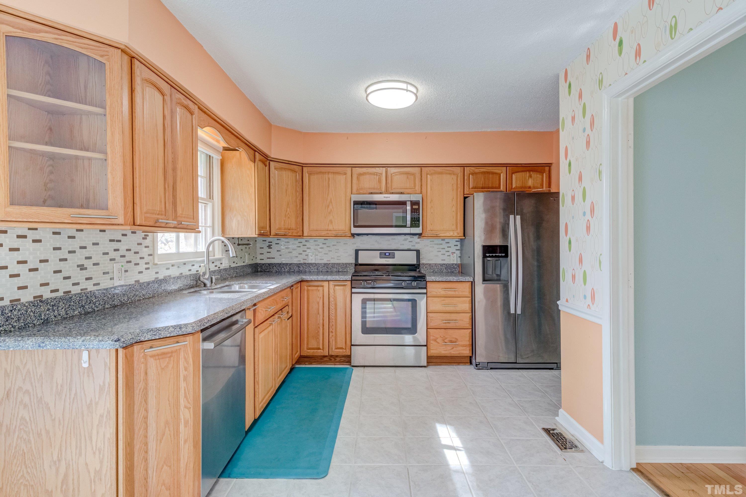 7008 Ray Road Raleigh, NC 27613 - Photo 3 of 36 a kitchen with stainless steel appliances granite countertop a refrigerator and a sink