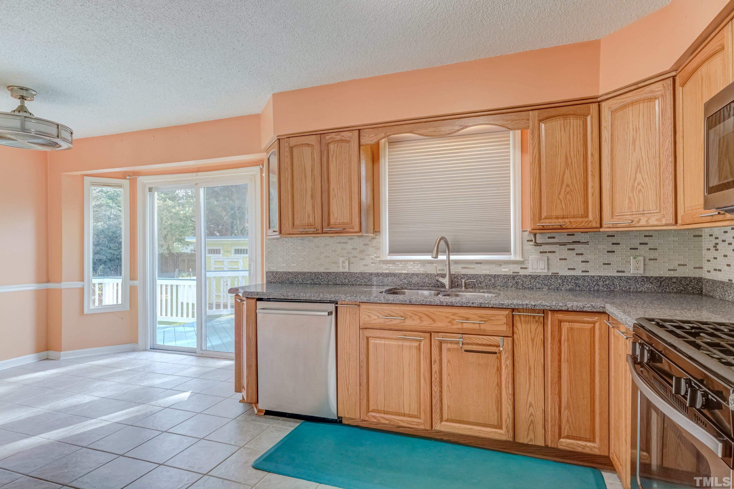 7008 Ray Road Raleigh, NC 27613 - Photo 4 of 36 a kitchen with granite countertop a sink and a stove