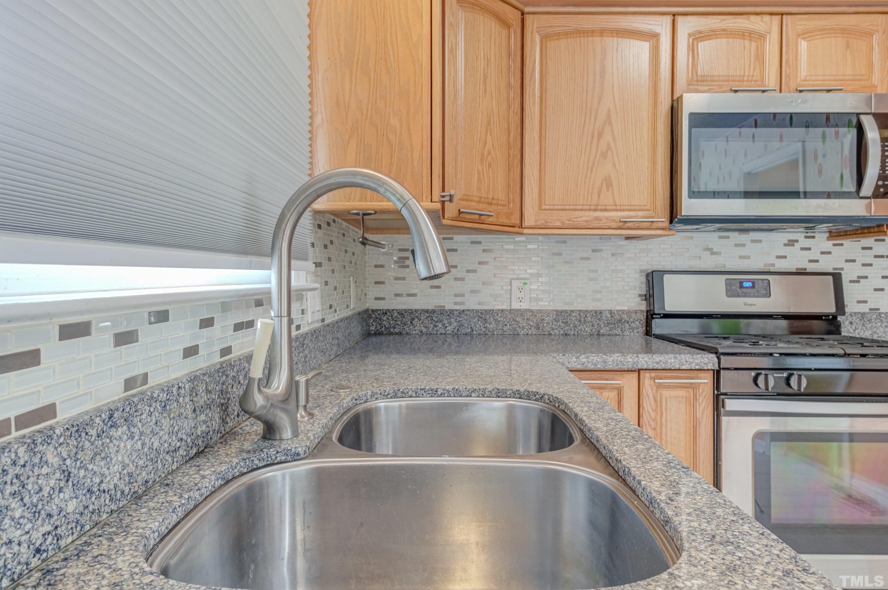 7008 Ray Road Raleigh, NC 27613 - Photo 6 of 36 a kitchen with stainless steel appliances granite countertop a sink a stove and cabinets
