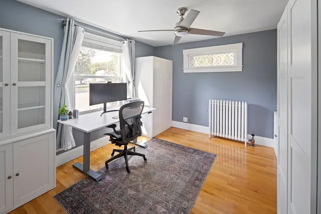 a view of a workspace with furniture and a window