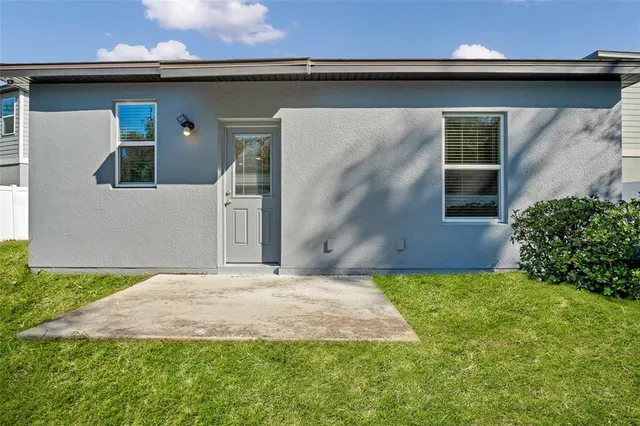 a backyard of a house with table and chairs