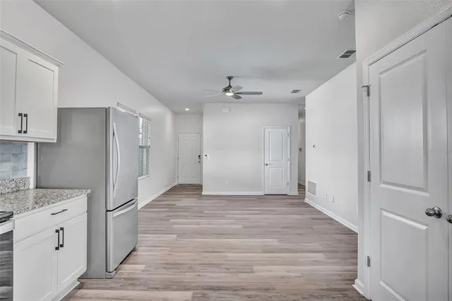 a view of a kitchen with a sink and refrigerator