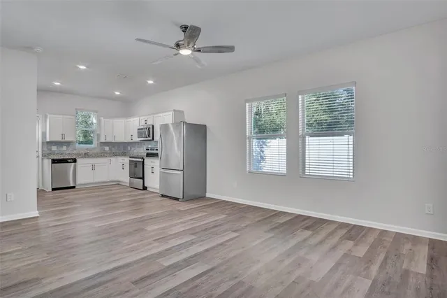 a view of kitchen with wooden floor electronic appliances and window