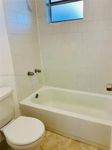 a white toilet and tub sitting next to a bathroom sink