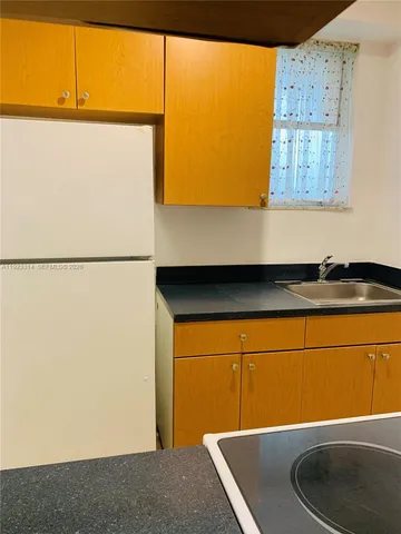 a kitchen with a refrigerator and a table