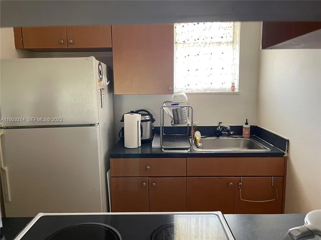 a kitchen with a refrigerator and a sink
