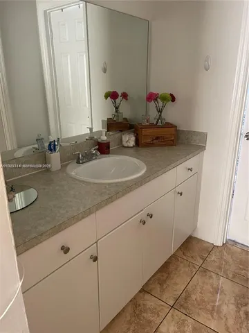 a bathroom with a granite countertop sink and a mirror