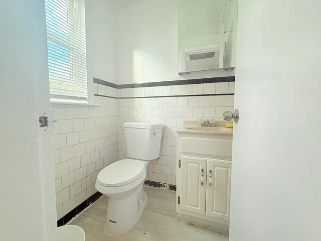 a bathroom with a toilet sink and a mirror