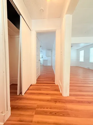 a view of a hallway with wooden floor and staircase