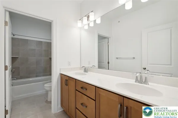a bathroom with a sink double vanity granite tub and a mirror