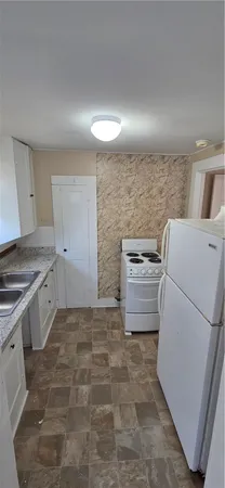 a kitchen with a refrigerator sink stove and cabinets