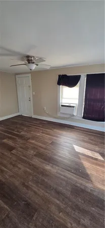 a view of empty room with window and wooden floor