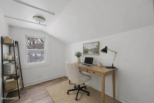 a view of a workspace with furniture and a window
