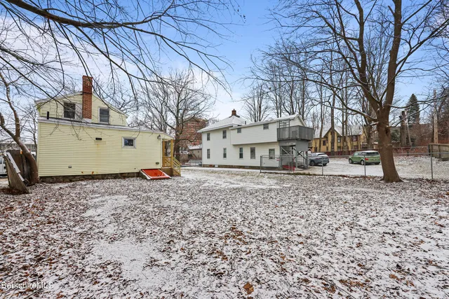 a view of a white house with a yard and covered with snow