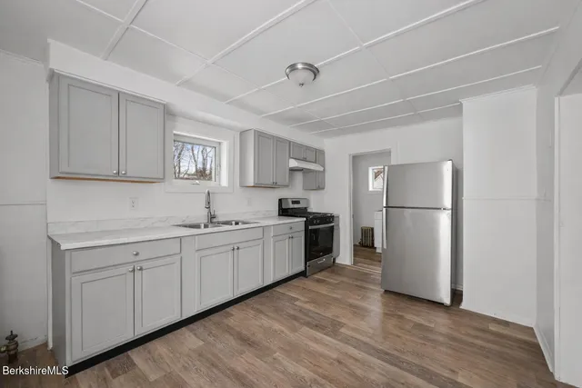 a kitchen with a sink stainless steel appliances and white cabinets
