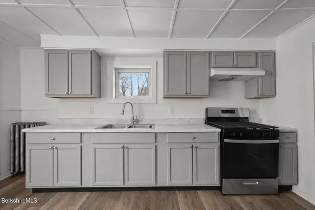 a kitchen with a stove sink and cabinets