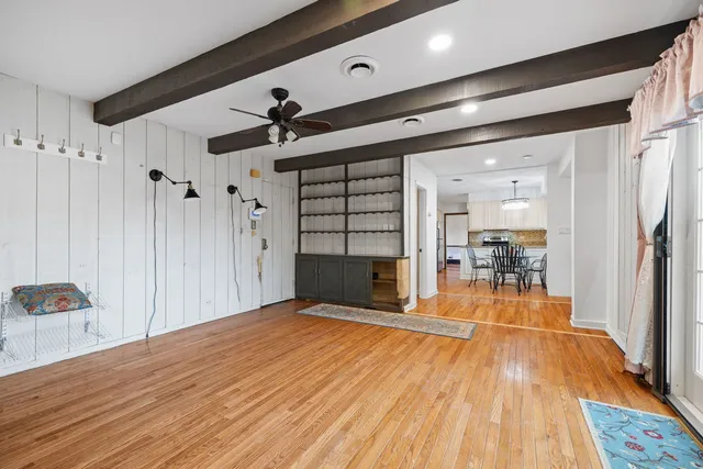a empty room with wooden floor and ceiling fan