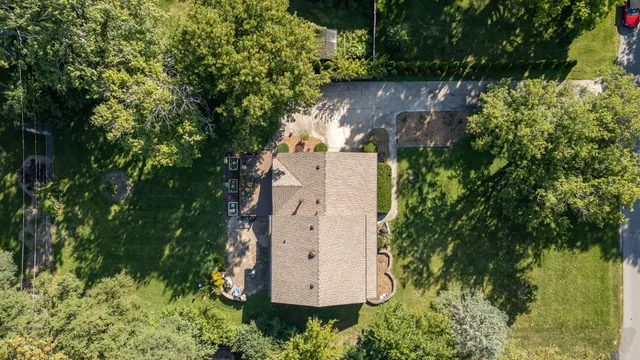 an aerial view of a house with a yard and large trees