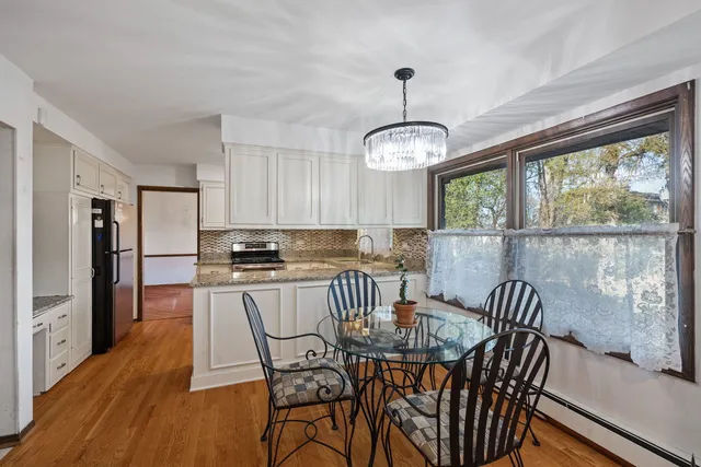 a view of a dining room with furniture a chandelier and wooden floor