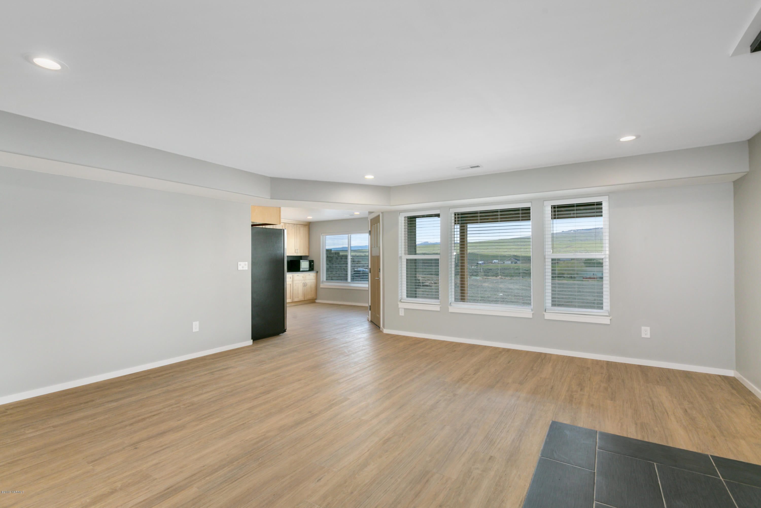 640 Winchester Road Yakima, WA 98908 - Photo 19 of 26 an empty room with wooden floor and windows