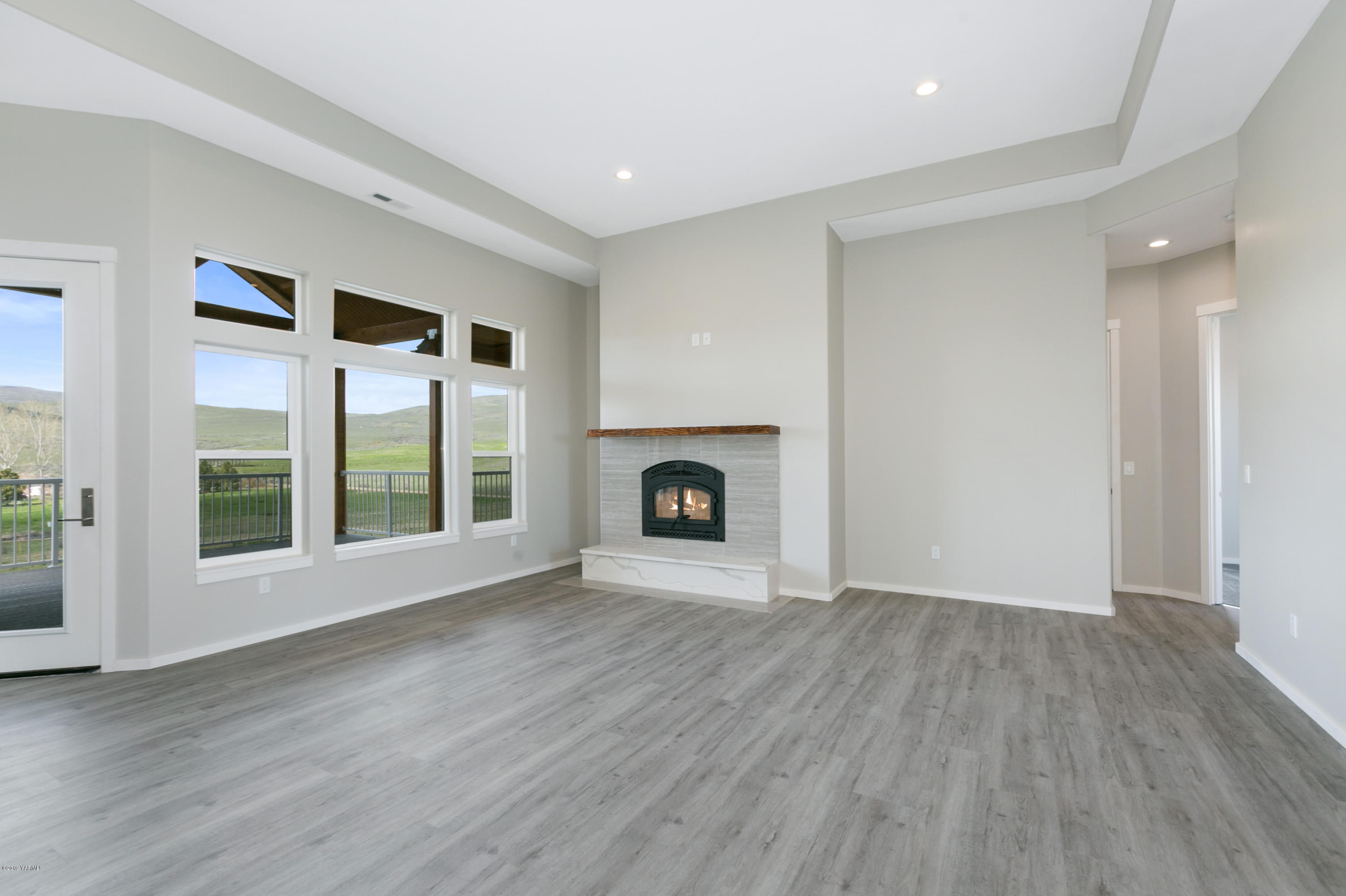 640 Winchester Road Yakima, WA 98908 - Photo 6 of 26 a view of an empty room with a fireplace and a window