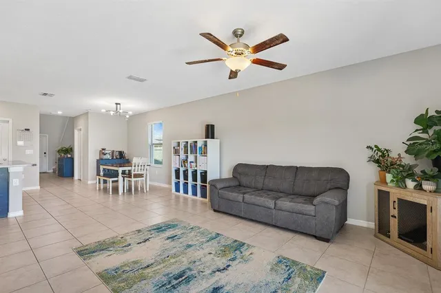 a living room with furniture and a dining table with kitchen view