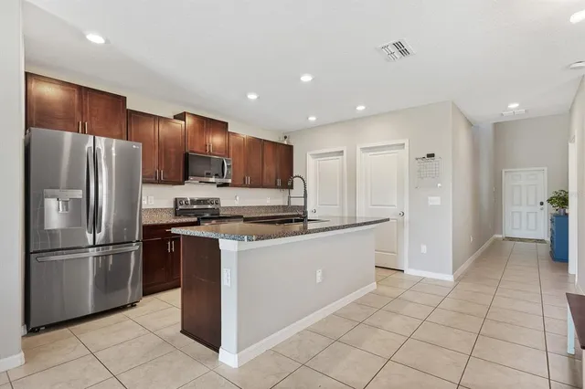 a kitchen with stainless steel appliances granite countertop a refrigerator and a sink
