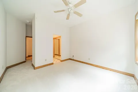 an empty room with a ceiling fan and a window