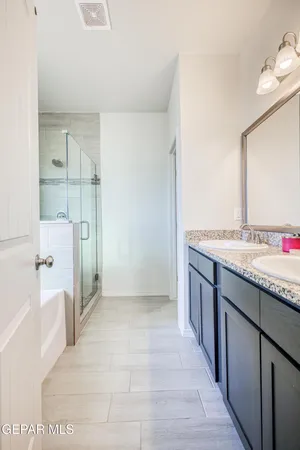 a bathroom with a granite countertop sink a mirror and shower