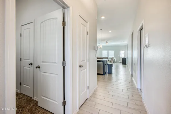 a view of a hallway with a dining table and chairs