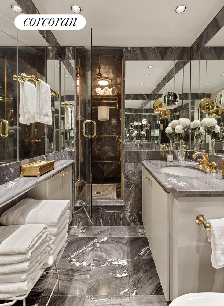 111 East 56th Street, Unit 1107 Manhattan, NY 10022 - Photo 4 of 6 a bathroom with a sink a mirror and a shower